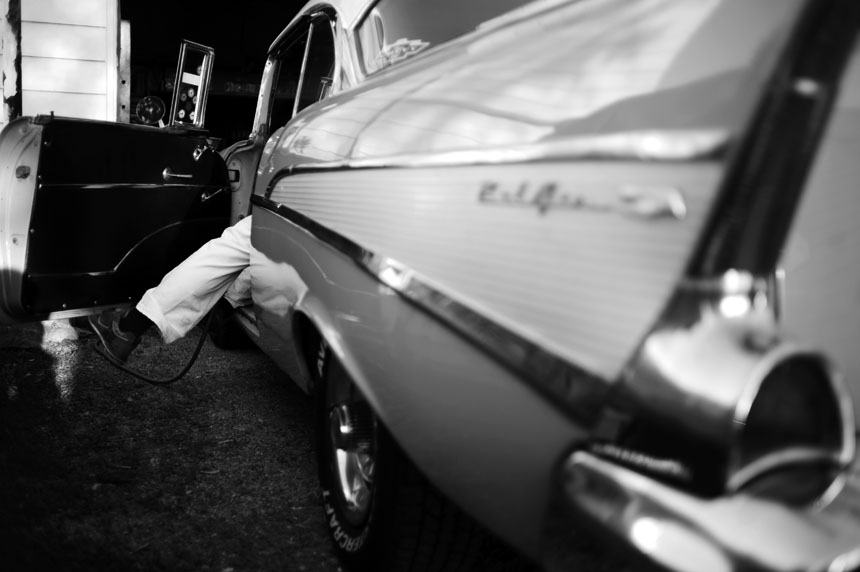 Tom Brosher dangles a leg outside of his 1957 Chevy Bel Air as he looks to cut a hole in the floor of the car for the shifter of his new 5-speed manual transmission on Thursday, May 6, 2010, in Dunkirk, Ind.