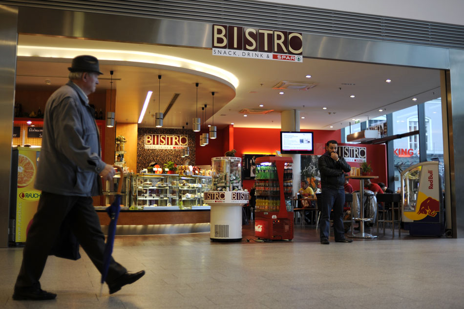 A man, right, waits to meet someone on Friday, May 21, 2010, in a shopping center in Salzburg, Austria.