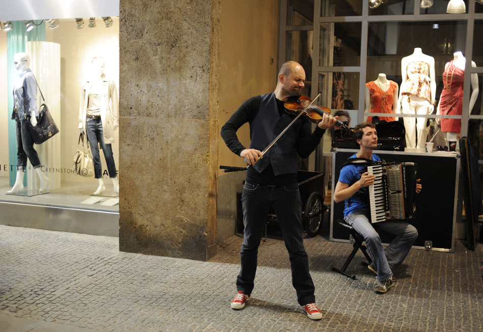 Violinist Igor Stravansky, of the group Konnexion Balkon, performs for pedestrians outside a clothing store on Monday, May 24, 2010, in Munich, Germany.