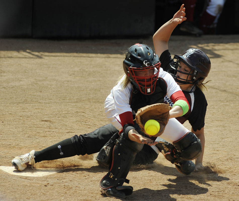 Magnolia's Madison Kraatz slides safely into home just in front of a throw to Canyon catcher Mandy Ogle in the top of the 10th inning during the UIL 4A softball semifinal at the University of Texas on Friday, June 4, 2010. Kraatz's score was the first of the game as Magnolia won 2-0 to advance to Saturday's 4A championship game.
