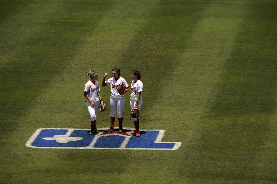 Canyon players Kailee Vrana, left, Chelsey Fisher and Andrea Robson talk in the outfield before the first pitch in a 4A softball semi-final against Magnolia at the University of Texas on Friday, June 4, 2010.