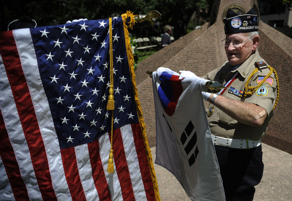Andrew "Buddy" Blair, a Korean War veteran, rolls up the American flag after a ceremony marking the 60th Anniversary of the start of the Korean War at the Texas Korean War Veterans Memorial on Friday, June 25, 2010.