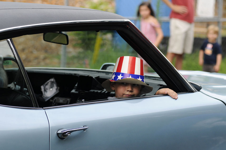 Michael Allen, age 6, looks back at the crowd assembled for the Tarrytown Fourth of July parade as he rides in his father's 1972 Buick Skylark Gran Sport on Saturday, July 3, 2010.