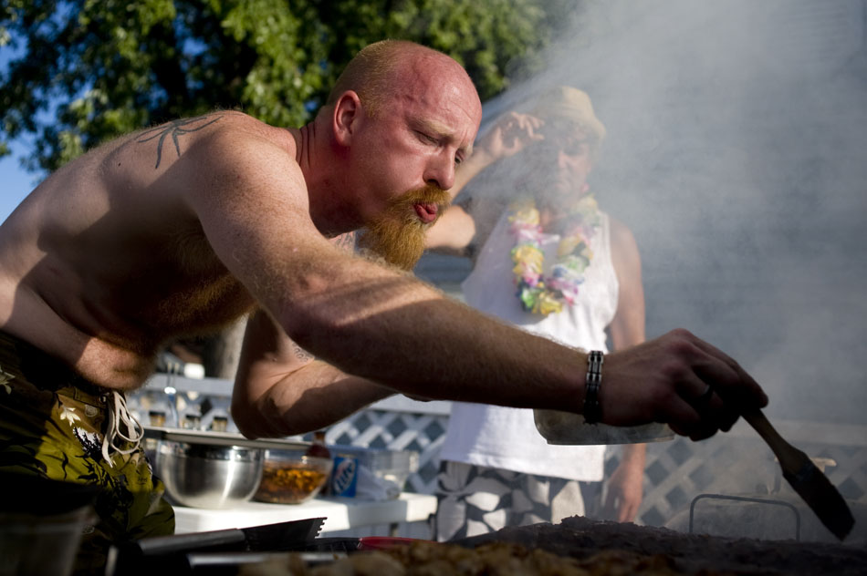Luke Merrill blows some smoke out of the way so he can find his ribs to baste them during a ribs cookoff on Sunday, Sept. 12, 2010, in Peoria Heights. The annual event pits a few friends against each other for bragging rights and a grilling fork.