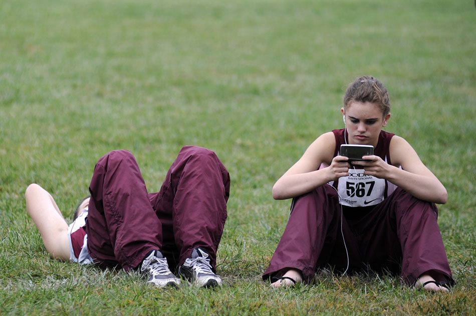 A sends a text message with her phone between races during the Woodruff Cross Country on Saturday, Sept. 11, 2010, in Detweiller Park.