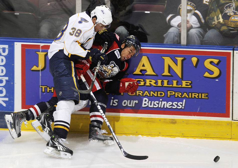 Peoria Rivermen right wing Ryan Reaves (38) checks Grand Rapids Griffins left wing Jordan Owens into the boards during a game on Saturday, Dec. 11, 2010, at Carver Arena.