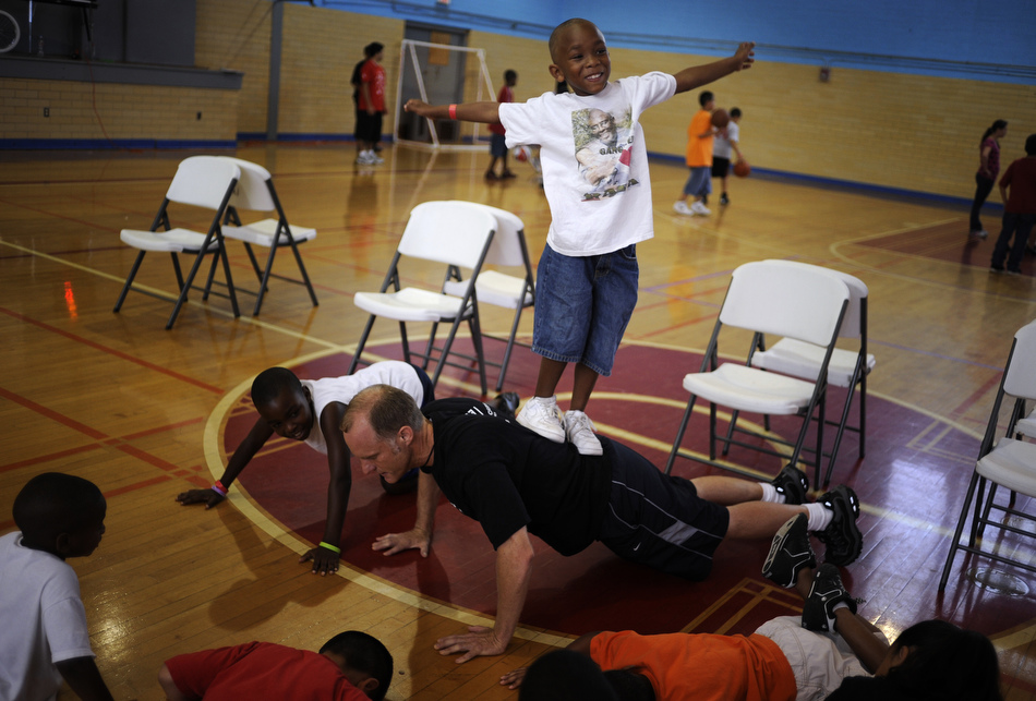 Larenz Dempz, age 7, tries to keep his balance as he stands on Brian Beavliev's back during a push up at the East Boys and Girls Club in Austin on Wednesday, June 16, 2010. Area youngsters participated in a Police Activities League basketball camp at the gymnasium.