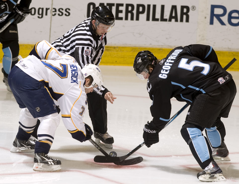 The official drops the puck for a face off between Peoria Rivermen center T.J. Hensick (7) and Milwaukee Admirals center Blake Geoffrion (5) during a game on Sunday, Dec. 5, 2010, at Carver Arena.