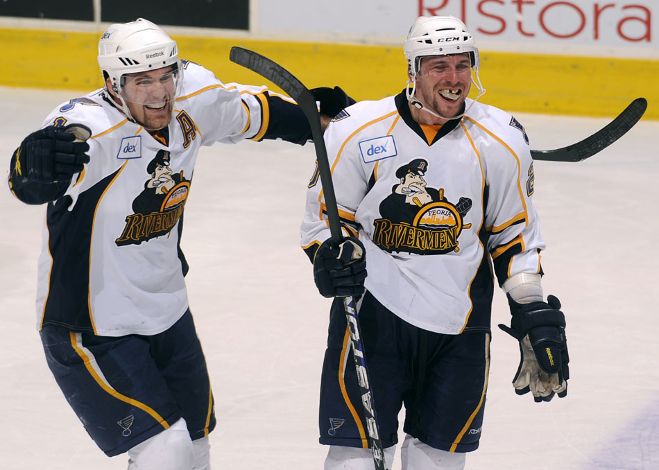 Peoria Rivermen right wing Graham Mink, left, celebrates with teammate Peoria Rivermen defender Nathan Oystrick after Oystrick scored a goal late in the third period of a game against Milwaukee on Sunday, Dec. 5, 2010, at Carver Arena.