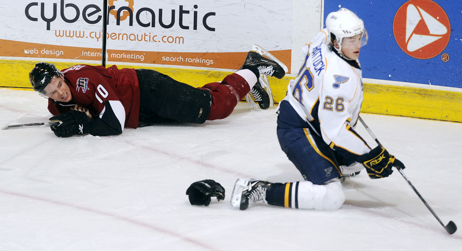 Lake Erie Monsters defender Matt Generous (10) lays on the ice after a hit from Peoria Rivermen right wing Tyler Shattock (26) during a game on Sunday, Dec. 19, 2010, at Carver Arena.