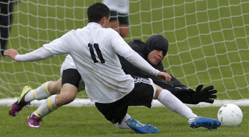 Cheyenne East's Trey Herrera (11) slides in to put a shot on goal as Green Rivers keeper Kenyon Baker dives to make the save during a Class 4A boy's state soccer fifth place game on Saturday, May 21, 2011, in Sheridan, Wyo.