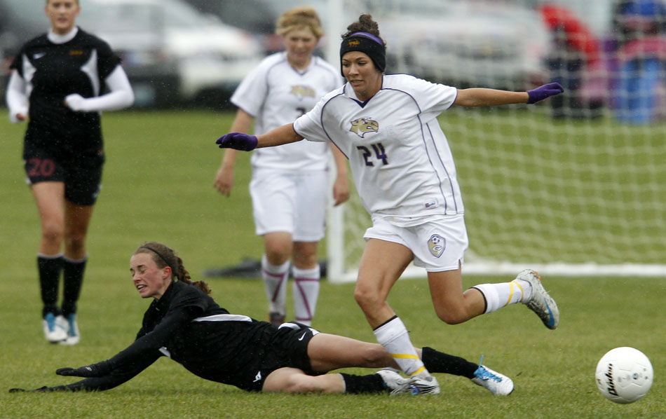 Laramie's Megan Dooley, left, falls to the pitch after drawing contact from Gillette's Michelle McGeary during the Class 4A girl's state soccer championship game on Saturday, May 21, 2011, in Sheridan, Wyo.