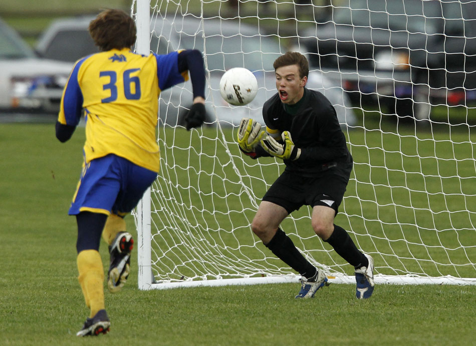 Laramie keeper Andrew Amen makes a save in front of Sheridan's Andrew Slikker (36) during the Class 4A boy's state soccer championship game on Saturday, May 21, 2011, in Sheridan, Wyo.
