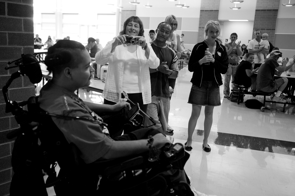 Maria Baca takes a quick snapshot of Isaac Salas as Salas rolls into a welcome home party on Saturday, Aug. 20, 2011, at Cheyenne South High School. Maria, who did not know Isaac or his family before his injury, became a quick friend of the family after she organized several charity events to raise money for his recovery. (James Brosher/Wyoming Tribune Eagle)