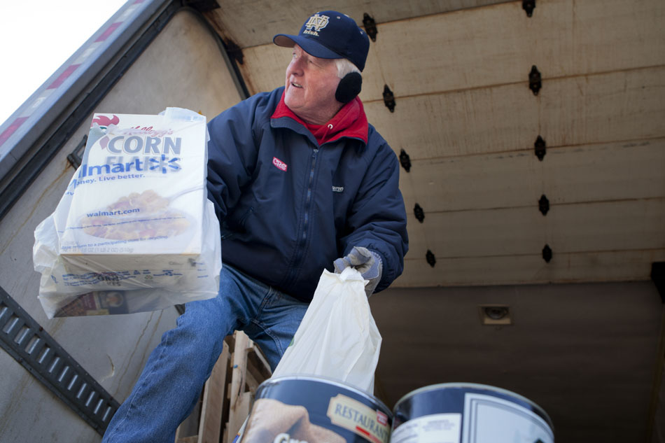 Volunteer Jack Gibboney grabs a few bags of food donations as he takes them to the back of a panel truck to be placed in bins during the Neighbors in Need donation drive for the Food Bank of Northern Indiana on Monday, Feb. 20, 2012, morning at the WSBT studios in Mishawaka. (James Brosher/South Bend Tribune)
