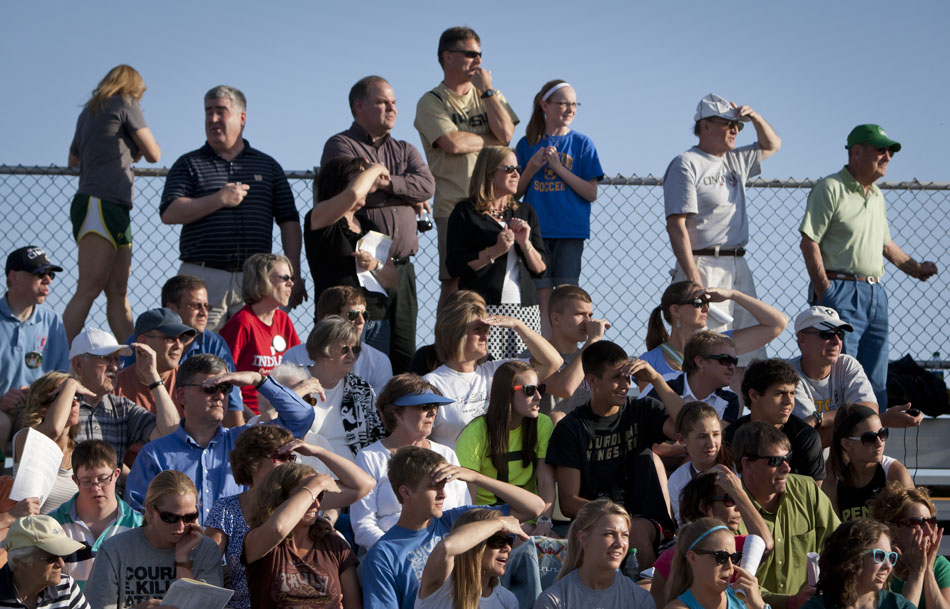 Parents and fans shade their eyes from the sun as they look westward to watch a relay final from the stands during the Bremen girl's track and field sectionals on Tuesday, May 15, 2012, at Bremen High School. (James Brosher/South Bend Tribune)
