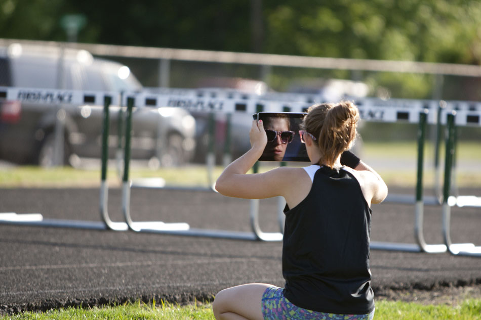 A spectator uses an iPad to photograph a hurdles event during the Bremen girl's track and field sectionals on Tuesday, May 15, 2012, at Bremen High School. (James Brosher/South Bend Tribune)