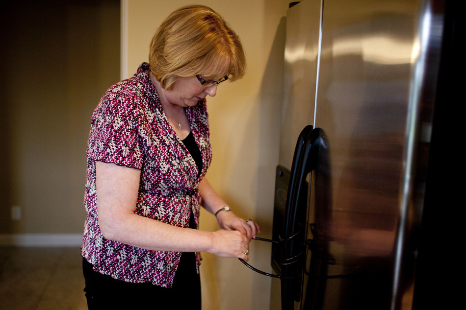 Debbie McKissick unlocks her refrigerator as she prepares to warm up dinner for her son, Greg Gaver, not pictured, on Wednesday, April 25, 2012, at their family home in Granger. Gaver, 21, suffers from Prader-Willi Syndrome which in part gives him an intense craving for food, promoting his parents to keep food in their home locked. (James Brosher/South Bend Tribune)
