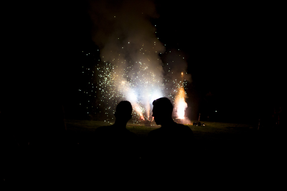 Party goers watch as a synchronized fireworks show in a backyard during the Annual Cruise on Land Summer Party on Saturday, July 25, 2015, in Bloomington, Indiana. (Photo by James Brosher)