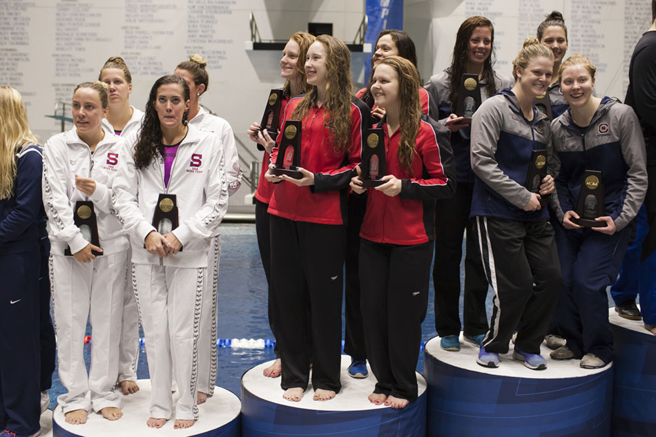 Drury's women's 800-yard freestyle relay team including Sarah Pullen, left, Megan Ouhl, Valentina Carvajal and Laura Brasier hold their trophies on the podium after finishing sixth at the NCAA Division II Swimming and Diving Championships on Friday, March 11, 2016, at the IU Natatorium in Indianapolis. (Photo by James Brosher)