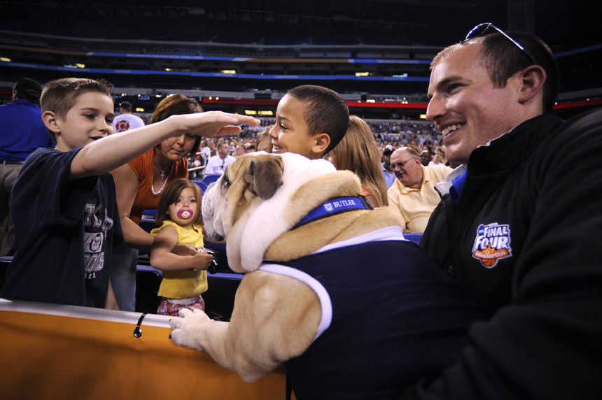 Michael Kaltenmark, a NCAA media services worker, holds Butler's Blue II, a bulldog, as a few youngers pet the school's mascot during Butler's open practice on Friday, April 2, 2010, at Lucas Oil Stadium. (James Brosher / IU Student News Bureau)