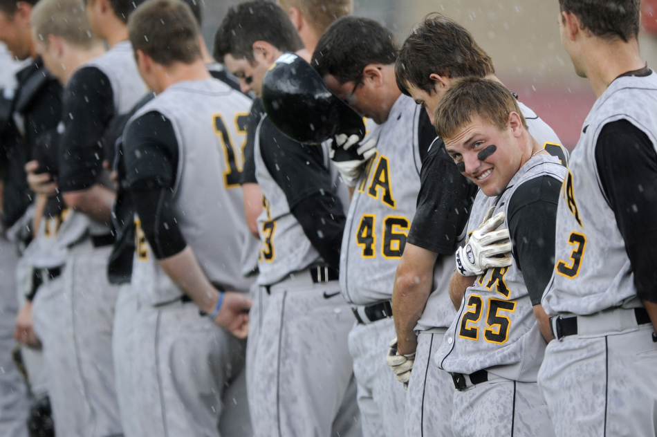 Iowa's Zach McCool (25) watches as a singer performs the National Anthem despite a sudden heavy rain shower before a game against Indiana on Friday, April 16, 2010, at Sembower Field in Bloomington, Ind. The game was postponed until Saturday due to rain and thunderstorms in the area.