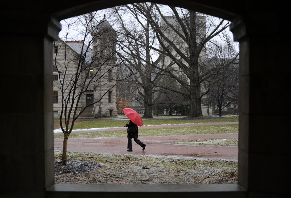 A women walks through a sleeting winter storm on Friday, Feb. 5, 2010, in the Old Crescent portion of the Indiana University campus in Bloomington, Ind. Above freezing temperatures turned an anticipated snow storm into rain and sleet for the early part of the day.