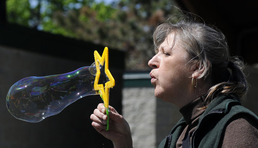 Jan Cravens, of Bloomington, blows a bubble for a youngster before the start of the Homeward Bound Walk on Sunday, April 18, 2010, at Third Street Park.