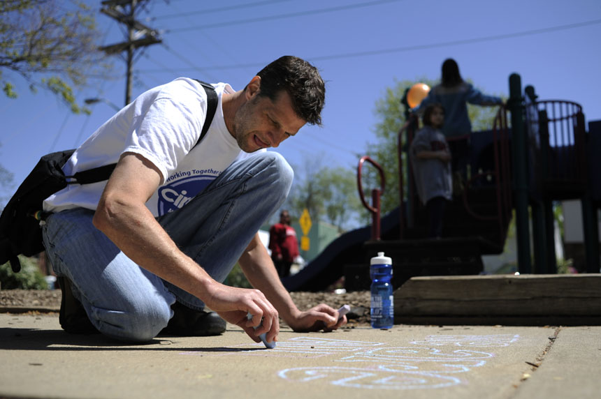 Patrick Siney, of Bloomington, works on a chalk drawing before the start of the Homeward Bound Walk on Sunday, April 18, 2010, at Third Street Park. Siney's drawing said, "We are all connected."