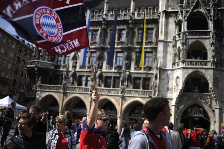 A Bayern München soccer fan waves a flag on Saturday, May 22, 2010, in the Marienplatz in downtown Munich, Germany. The city's team was playing later that evening for a European championship, drawing several fans to the city to watch or take part in fan activities.