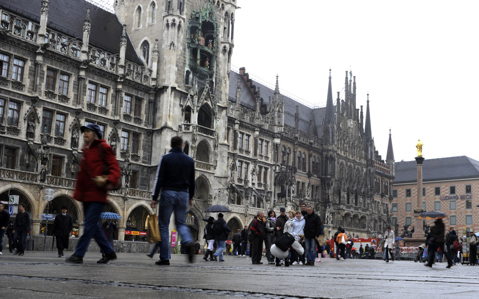 Tourists and visitors make their way through Marienplatz in front of city hall, at left, on Thursday, May 20, 2010, in Munich. Temperatures in the 40s combined with fickle rain didn't stop many from seeing the sights on Thursday afternoon.