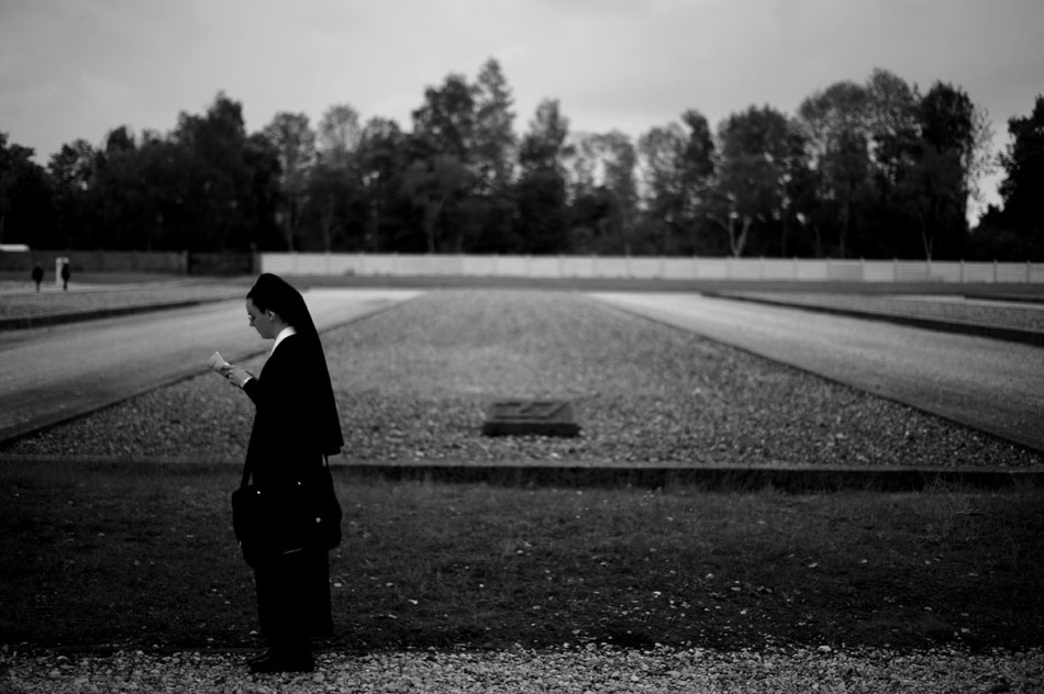 A nun inspects a map as she makes her way through the Dachau Concentration Camp on Saturday, May 22, 2010, in Dachau, Germany. Behind her is a foundation (No. 27) showing visitors where one of the prisoner barracks stood during the camp's operation. Each empty foundation is numbered.