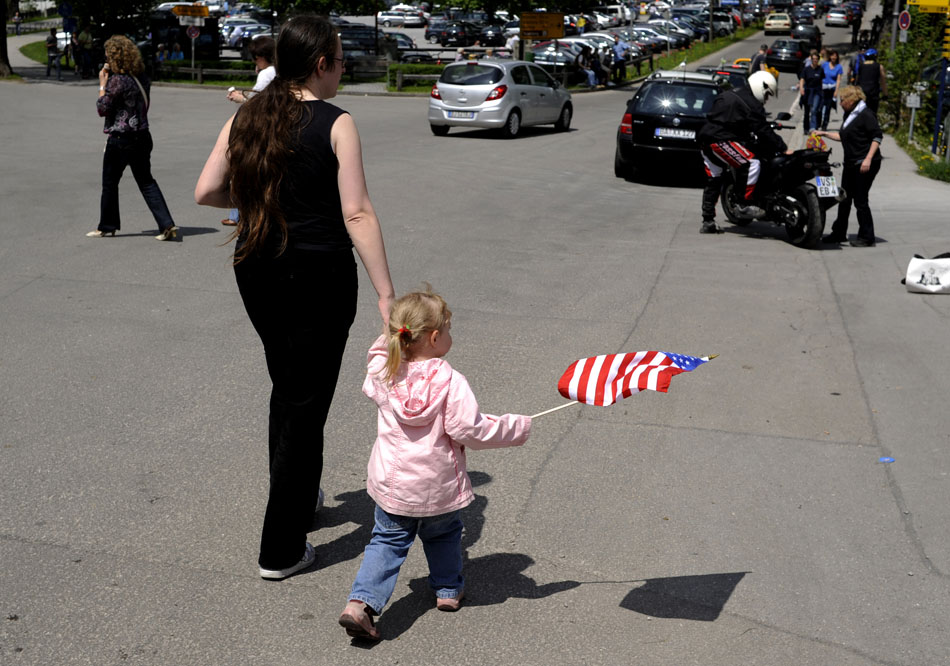 A girl carries an American flag through the streets of Schwangau, Germany on Sunday, May 23, 2010, in the German state of Bavaria. Good weather and a national holiday combined to attract several local and foreign visitors to the castle.