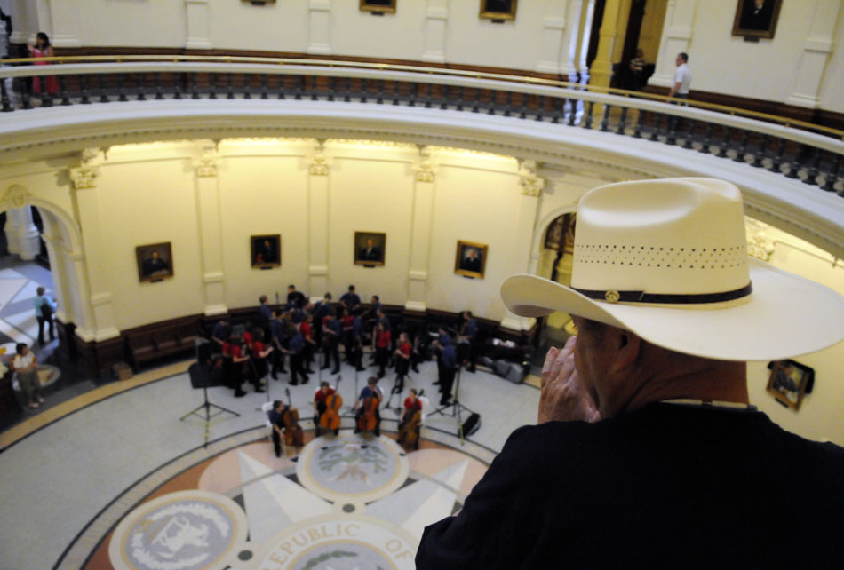 A visitor watches as the Saline Fiddlers perform in the rotunda of the Texas State Capital on Wednesday, June 30, 2010. The group of 29 Saline, Mich. high school students are currently touring Texas.