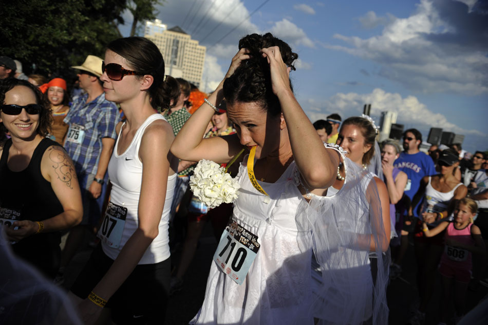 A runner dressed as a bridesmaid straightens her hair before starting the Keep Austin Weird 5K on Saturday, June 26, 2010.