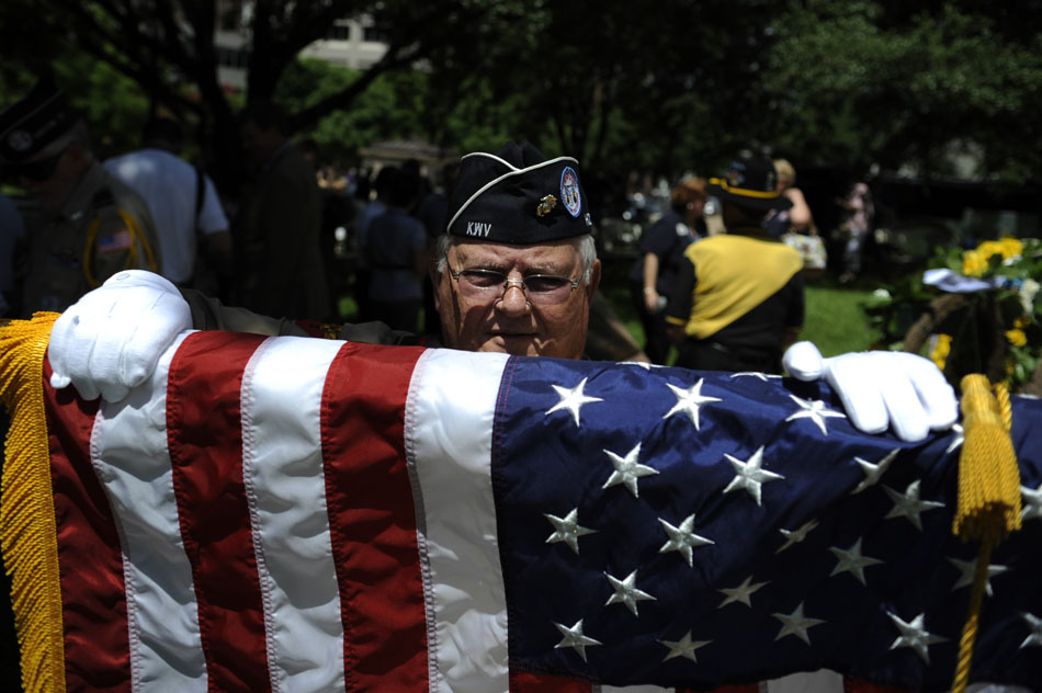 Carlos Ballard, a Korean War veteran, rolls up an American flag used in a ceremony marking the 60th anniversary of the start of the Korean War at the Texas Korean War Veterans Memorial on Friday, June 25, 2010.