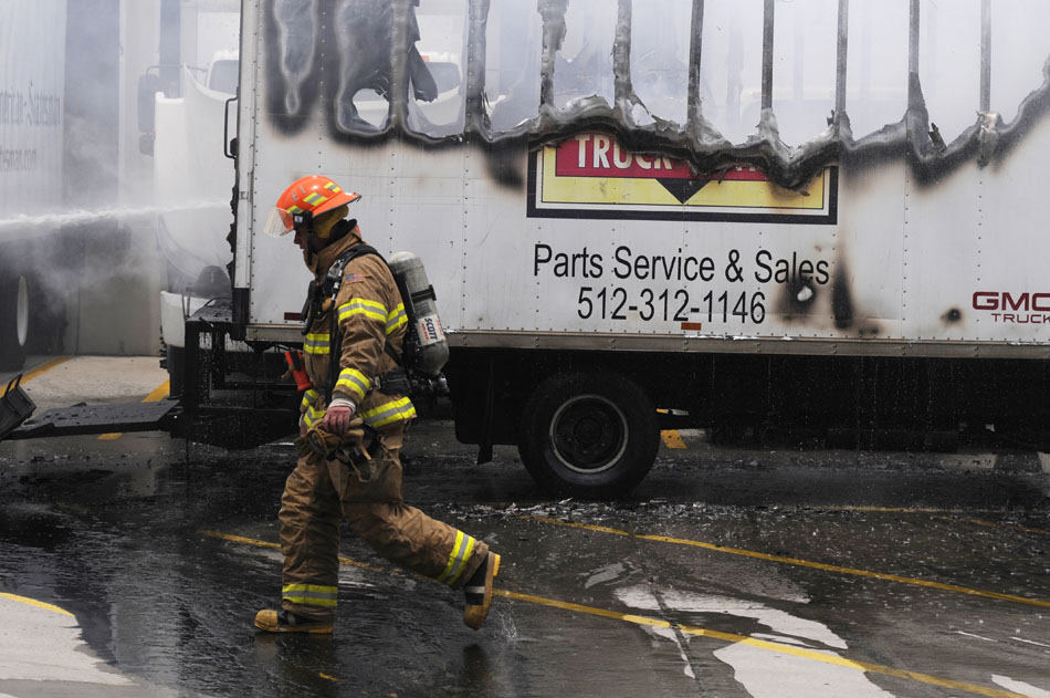 An Austin firefighter walks past the remains  of a truck service parts truck after it caught fire in the parking lot of the Austin American-Statesman on Tuesday, June 8, 2010.