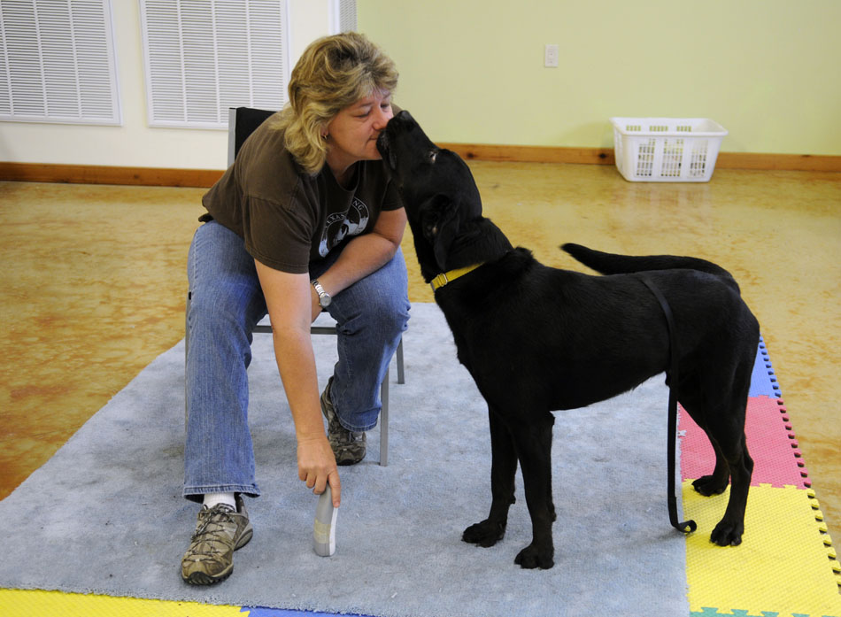 Ginny Stover gets a surprise kiss from Courage, a service dog in training, while teaching the dog to retrieve a cordless phone at Texas Hearing and Service Dogs in Dripping Springs on Thursday, June 3, 2010. Trainers expect Courage to be done with his training in two to three months.