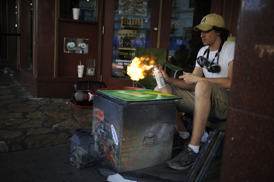 A street artist works on a spray painting as he uses a lighter to momentarily turn his paint can into a flame thrower on Saturday, July 31, 2010, in San Antonio, Texas.