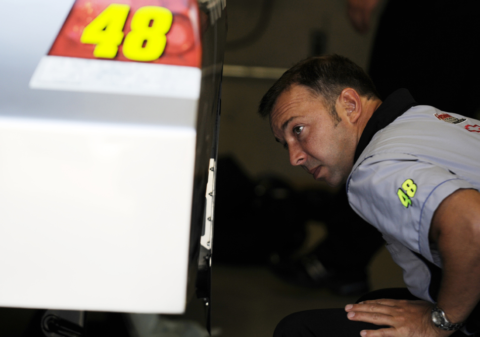 Chad Knaus, the crew chief of the No. 48 Chevrolet driven by defending Brickyard winner Jimmy Johnson, looks into the rear wheel-well as the crew makes final adjustments before final inspection on Sunday, July 26, 2009, at the Indianapolis Motor Speedway.