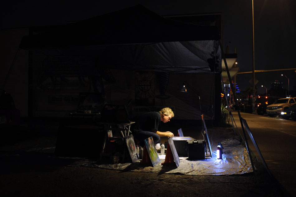 Leland Smith, a local painter, works on a piece under a canopy as a drizzling rain mists the area during SoCo First Thursday on Thursday, July 1, 2010. "I gave it up for 20 years," Smith said of his work, but says he is painting again after the hiatus.