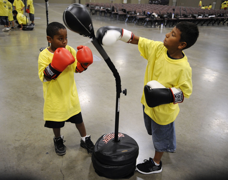 David Santos, left, and Lemon Bonner, both age 9, take jabs at a speed bag during a Police Activities League boxing clinic at the Palmer Events Center on Monday, July 12, 2010.