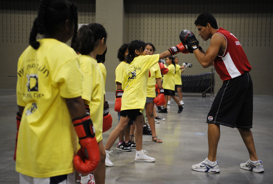 Alexis Camacha takes jabs from a group of youngsters during a Police Activities League boxing clinic at the Palmer Events Center on Monday, July 12, 2010.