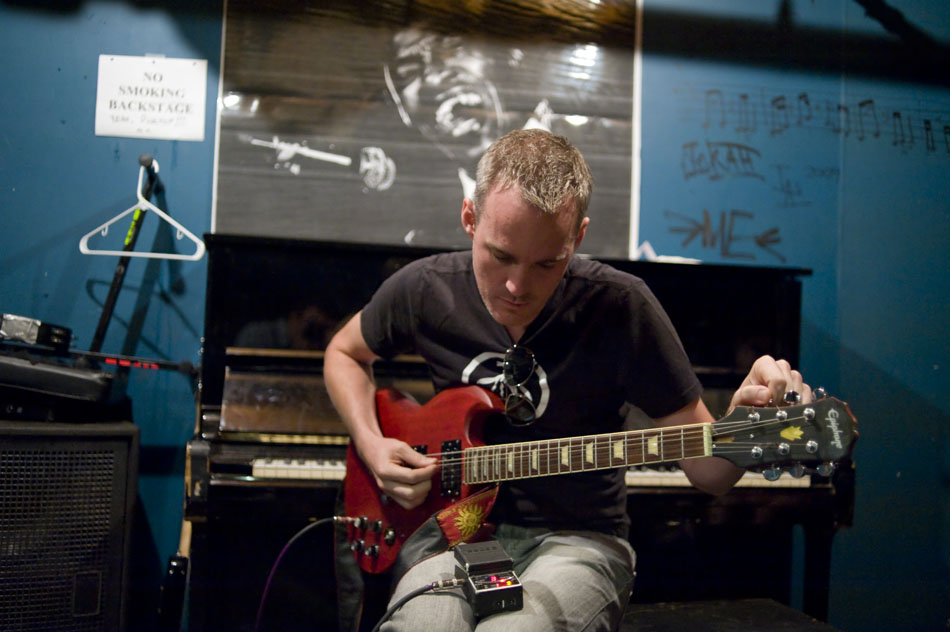 Instructor John Branch tunes up a guitar for a member of the band Fat Boy and the Midnight Snackie in the green room before the bands set during the Rock Camp USA concert at Antone's on Saturday, July 24, 2010.