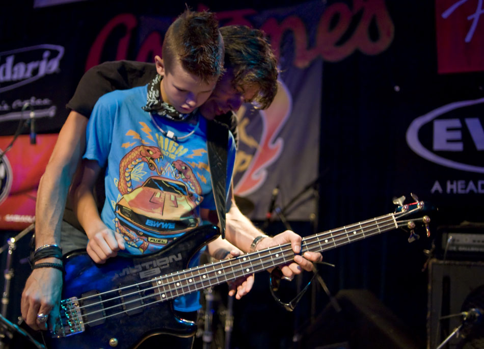 Charlie Sexton helps get his son, Marlon, situated with a bass guitar before a set during the Rock Camp USA concert at Antone's on Saturday, July 24, 2010.