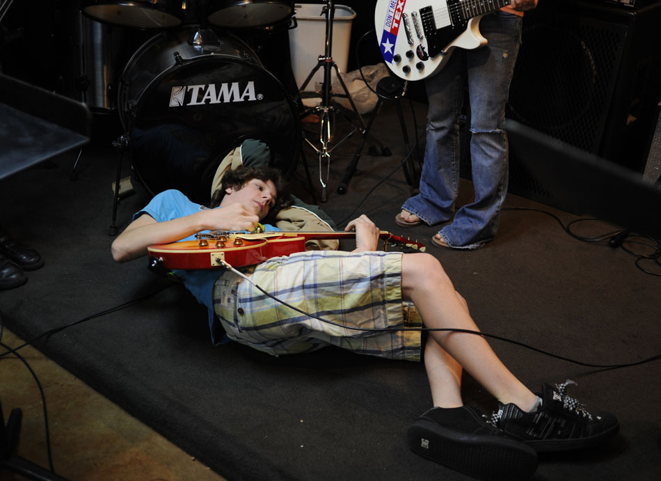 Mason Crowell, age 13, uses a blanket from the inside of a bass drum as a pillow as he plays a lick on his guitar from the stage floor during a rehearsal at the Austin School of Music's Rock Camp USA on Wednesday, July 21, 2010. Crowell was rehearsing with his band, Hatin' on the Hair.