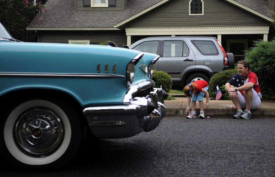 William Heyer, right, scopes out a classic 1957 Chevy Bel Air as his daughter, Nichol, age 6, grabs a few pieces of candy during the Tarrytown Fourth of July parade on Saturday, July 3, 2010.