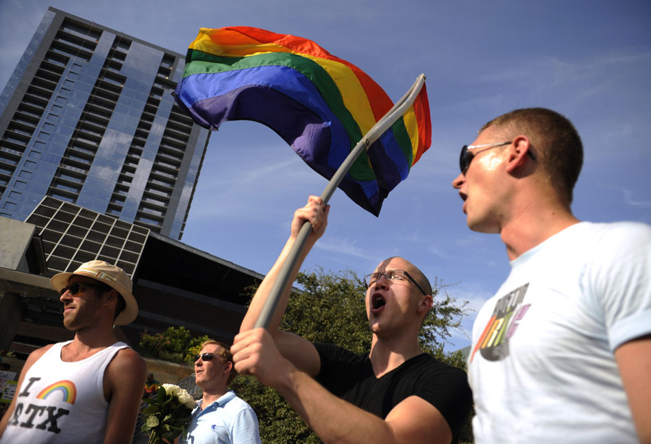 A gay rights activist waves a gay pride flag during a rally at Austin City Hall on Wednesday, Aug. 4, 2010.