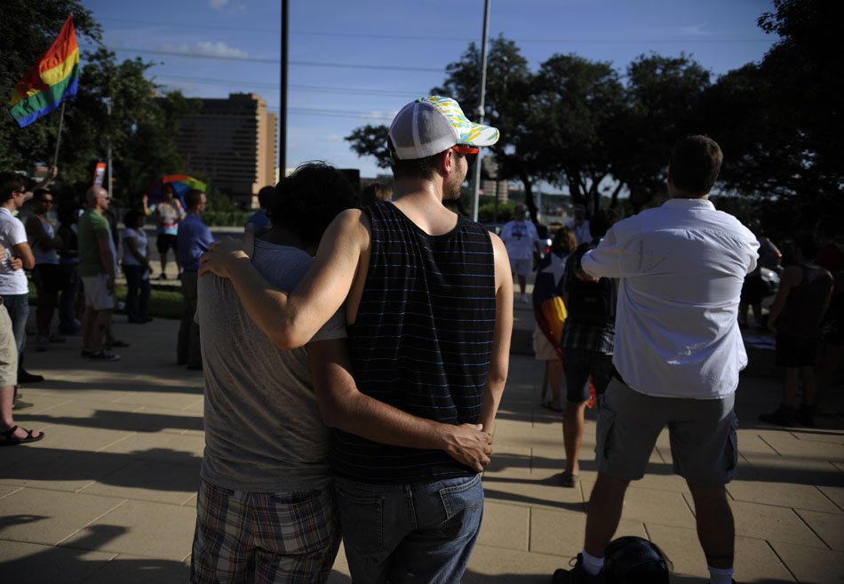 A couple watch a gay rights rally from the back of the crowd at Austin City Hall on Wednesday, Aug. 4, 2010. Earlier in the day a U.S. District Court in San Francisco overturned the controversial legislation, deeming it unconstitutional.