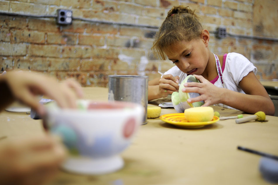 Taylor Hierman,  age 8, concentrates on applying some green paint to a bowl on Monday, Sept. 13, 2010, at Fired Up! in Peoria Heights. Hierman was one of several YWCA child care kids who painted bowls on Monday to be sold for charity at Soup for the Shelter on Nov. 16.